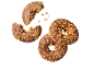 Chokladdoughnuts med karamellbitar, en biten, på svart bakgrund.