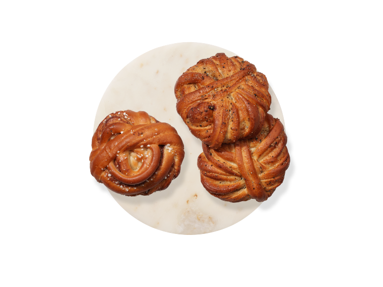 Kanelbullar och kardemummabullar på en marmorplatta.