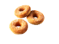 Tre gyllene ringmunkar med socker på svart bakgrund.