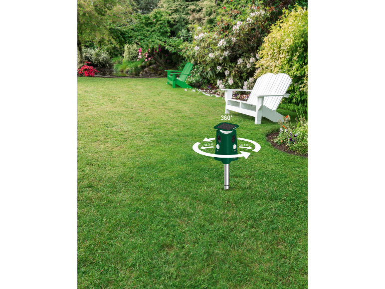 Solcellsdriven ultraljudsskrämma i en trädgård med gräsmatta och stolar.