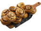 Kanelbullar med pärlsocker på en träskärbräda och tygservett.