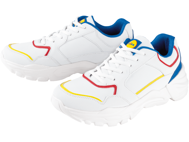 Vita sneakers med röda, gula och blå detaljer mot svart bakgrund.