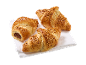 Tre nöttoppade croissanter, en fylld med choklad, på en vit servett.