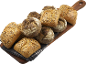 Flerkornsbullar och fullkornsrundbröd på en träskärbräda.