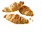 Tre gyllene croissanter med krispig skorpa på svart bakgrund.