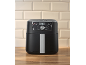 Svart airfryer med digital kontrollpanel på träbänk och beiga kakelplattor.