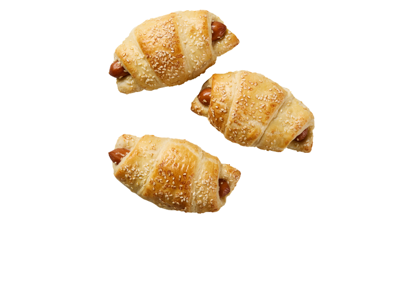 Tre salta croissanter med korv och sesamfrön på svart bakgrund.