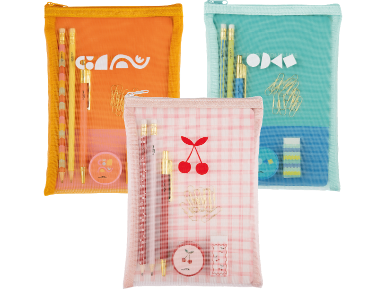 Tre genomskinliga pennfodral med skrivmaterial: orange, blått och rosa med körsbär.