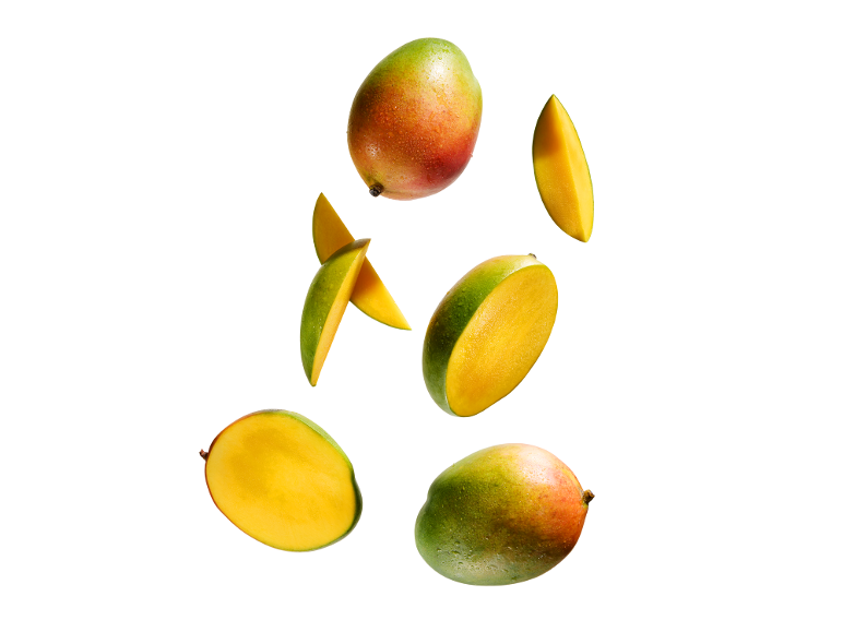 Färska hela och skivade mangofrukter med vattendroppar.