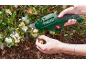 Elektrisk sekatör klipper vita blommor på en buske.