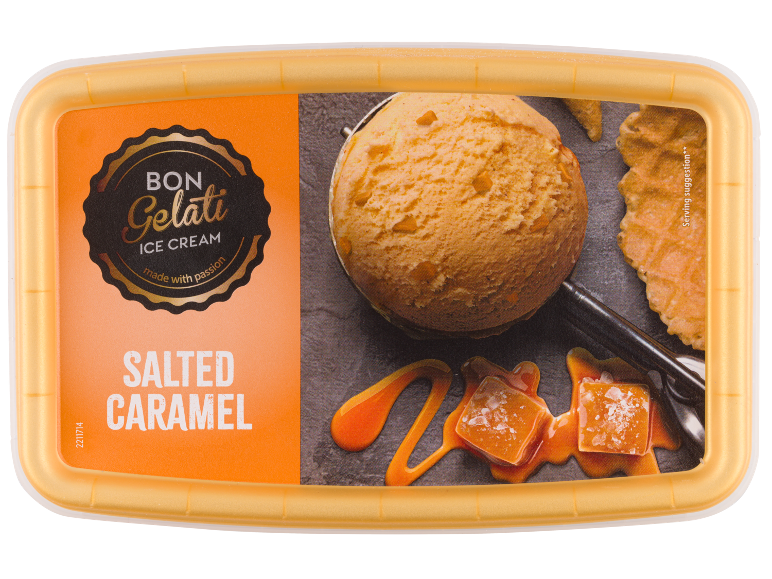 Salt karamellglass med en kula, karamellsås och karamellbitar.