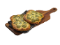 Pesto- och ostfocaccia på en träskärbräda med en duk.