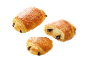 Tre chokladcroissanter, en halverad, mot svart bakgrund.