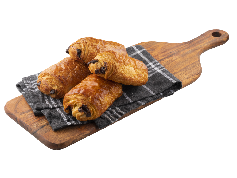 Fyra gyllenbruna pain au chocolat på en rutig kökshandduk på en träskärbräda.