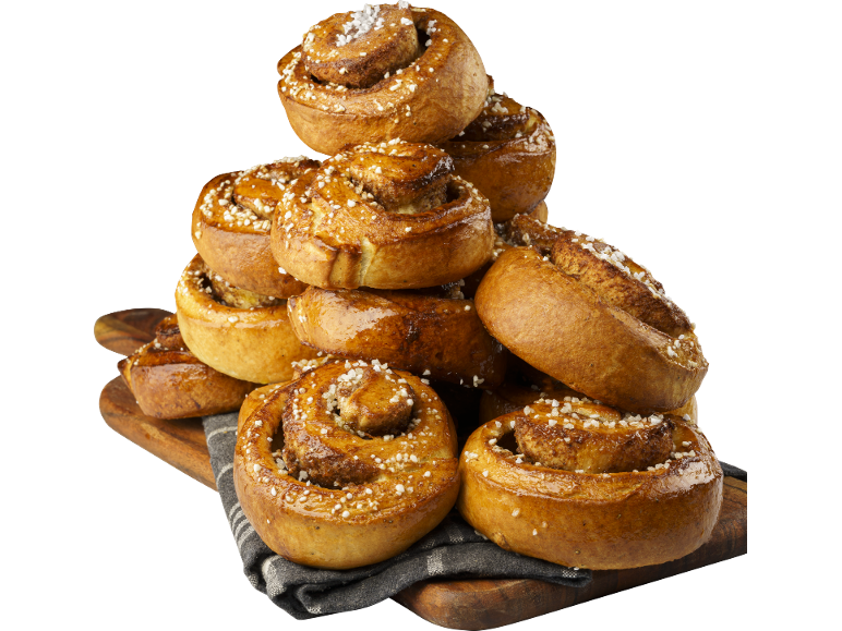 En hög med glaserade kanelbullar, strödda med socker, på en träskiva.