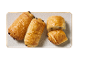 Gyllenbruna chokladcroissanter på en rektangulär tallrik, en halverad.