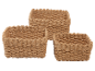 Set med tre vävda korgar av naturfibrer i beige.