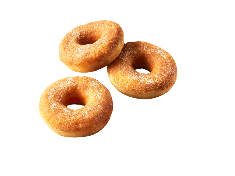 Tre gyllene ringmunkar med socker på svart bakgrund.