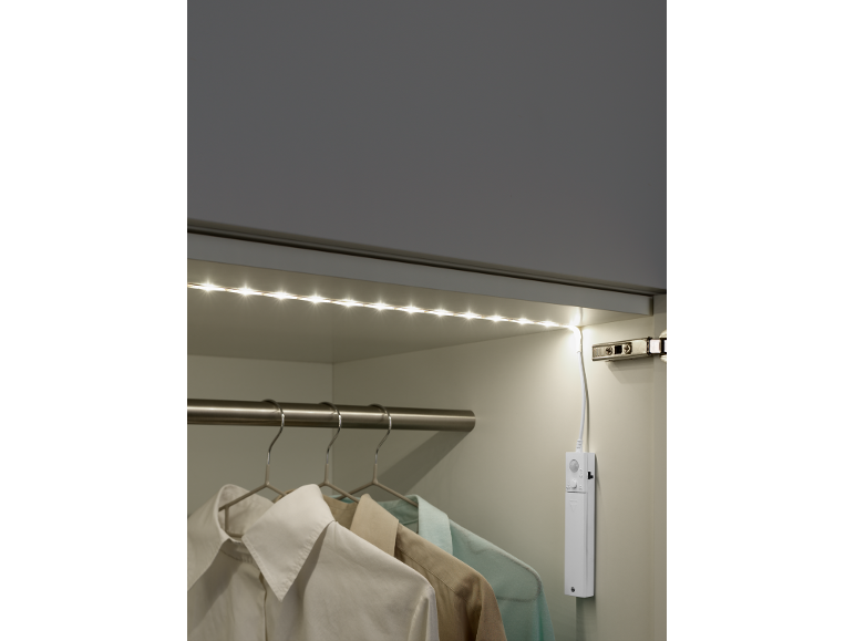 LED-list med rörelsesensor i en garderob med kläder.