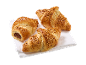 Tre nöttoppade croissanter, en fylld med choklad, på en vit servett.