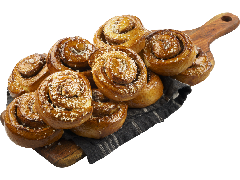 Kanelbullar med pärlsocker på en träskärbräda och tygservett.
