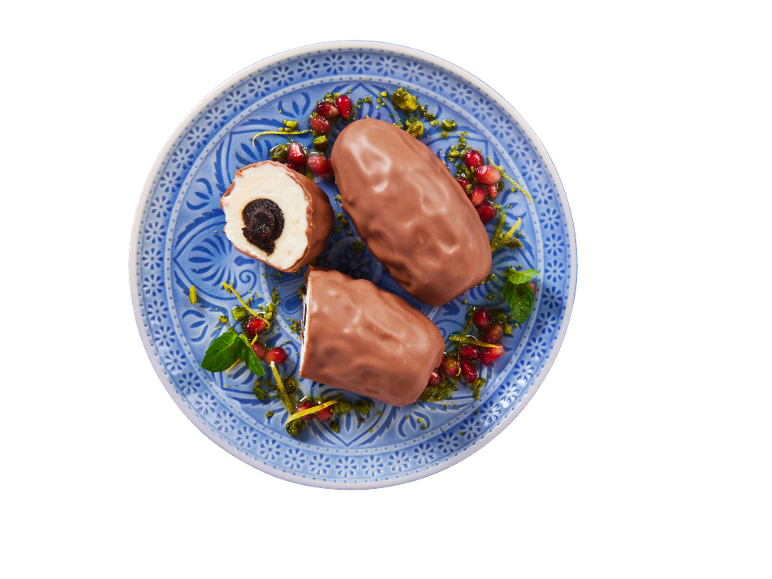 DELUXE chokladbakelser med fyllning, garnerade med pistagenötter och granatäpple.
