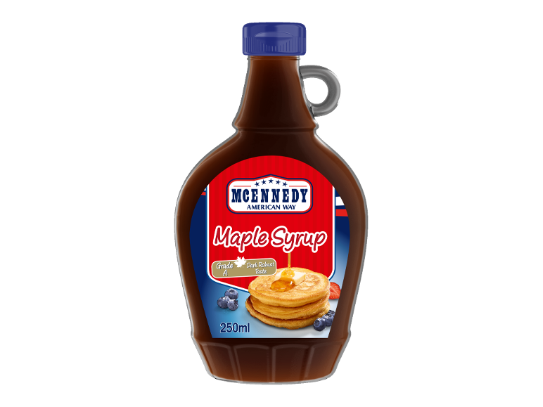 Lönnsirapsflaska med röd etikett, pannkakor och bär.