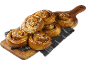 Kanelbullar med pärlsocker på en träskärbräda och tyg.