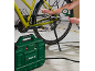 En grön luftkompressor pumpar ett cykeldäck, med en tryckmätare som visar trycket.