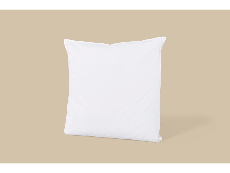 En vit kudde på en beige bakgrund.