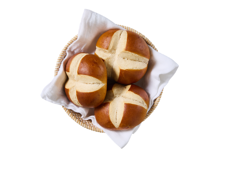 Tre kringelbullar i en flätad korg fodrad med en vit servett, ovanifrån.