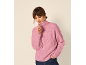 Kvinna i rosa halvdragkedja stickad tröja och jeans, tittar ner och justerar dragkedjan.