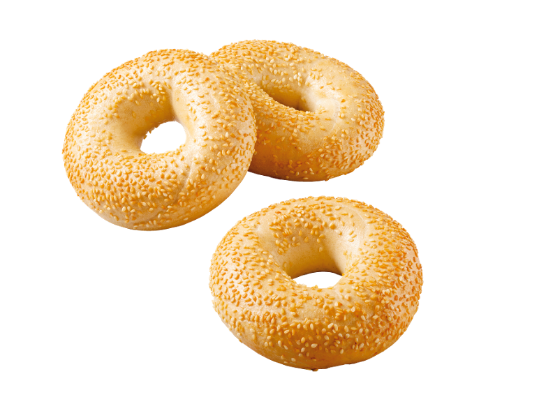 Tre sesambagels på svart bakgrund