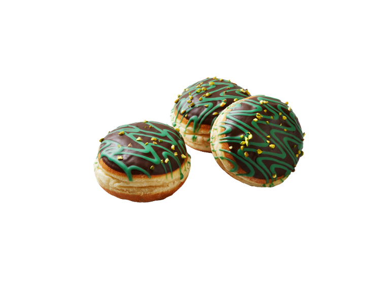 Tre munkar med chokladglasyr, dekorerade med grön glasyr och hackade pistagenötter.