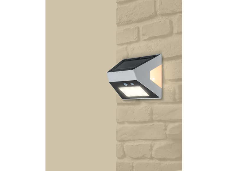 Solcellsvägglampa med rörelsesensor på en tegelvägg