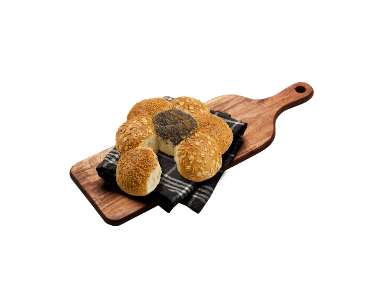 Blandade bullar med frön och havre på en träskärbräda och en duk.