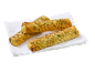 Tre gyllene, tvinnade bakverk med grön topping, på en vit servett.
