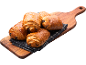 Nybakade pain au chocolat på en träskärbräda med en duk.
