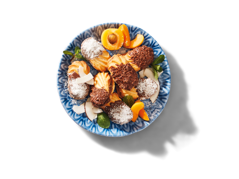 Tallrik med kakor med choklad, kokos, mynta och aprikoser.