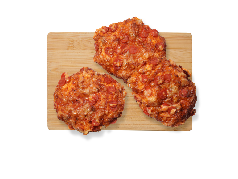 Tre mini pepperoni-pizzor på en skärbräda i trä.
