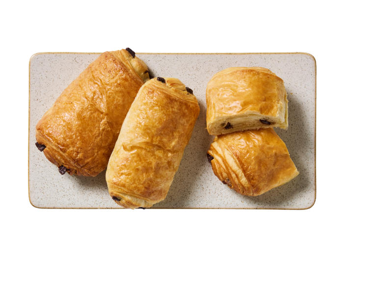 Gyllenbruna chokladcroissanter på en rektangulär tallrik, en halverad.