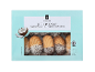 Låda med kokos petit four med aprikosfyllning, delvis doppade i choklad.