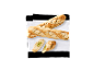 Två skivade baguetter och två baguetteskivor med pesto på en vit duk.
