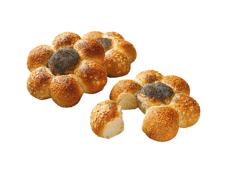 Blomformat bröd med sesam, vallmofrön och havre, ett delvis brutet.