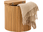 Förvaringspall i trä med en ljusbeige filt draperad över sidan.