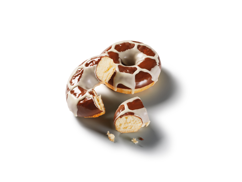 Delvis uppäten munk med choklad och vit glasyr, med smulor.