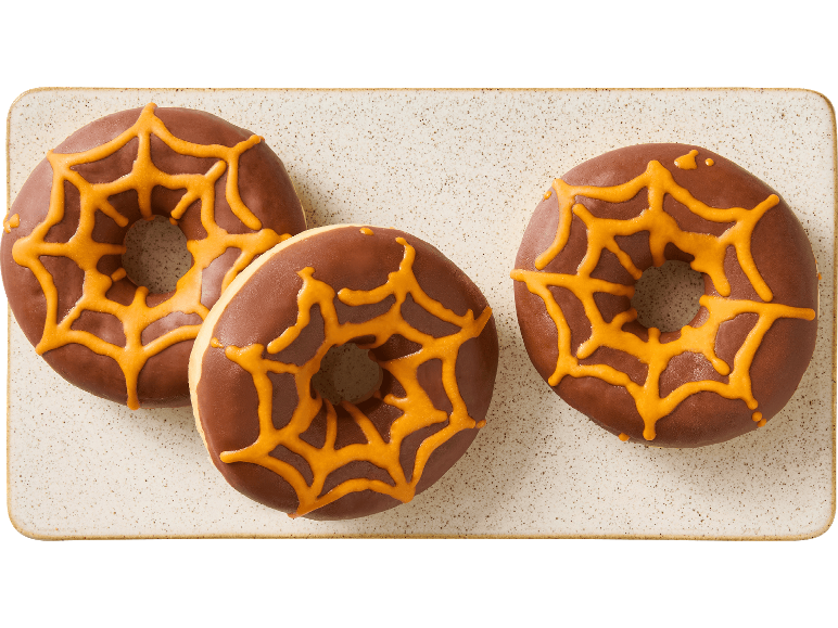 Tre halloween-donuts med chokladglasyr och orange spindelnät på en bricka