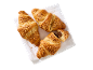 Tre croissanter med nötter på en vit handduk, en med chokladfyllning.