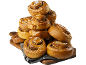 En hög med glaserade kanelbullar, strödda med socker, på en träskiva.
