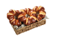 Flätad korg med bruna bullar arrangerade i hjärtform på en grå duk.